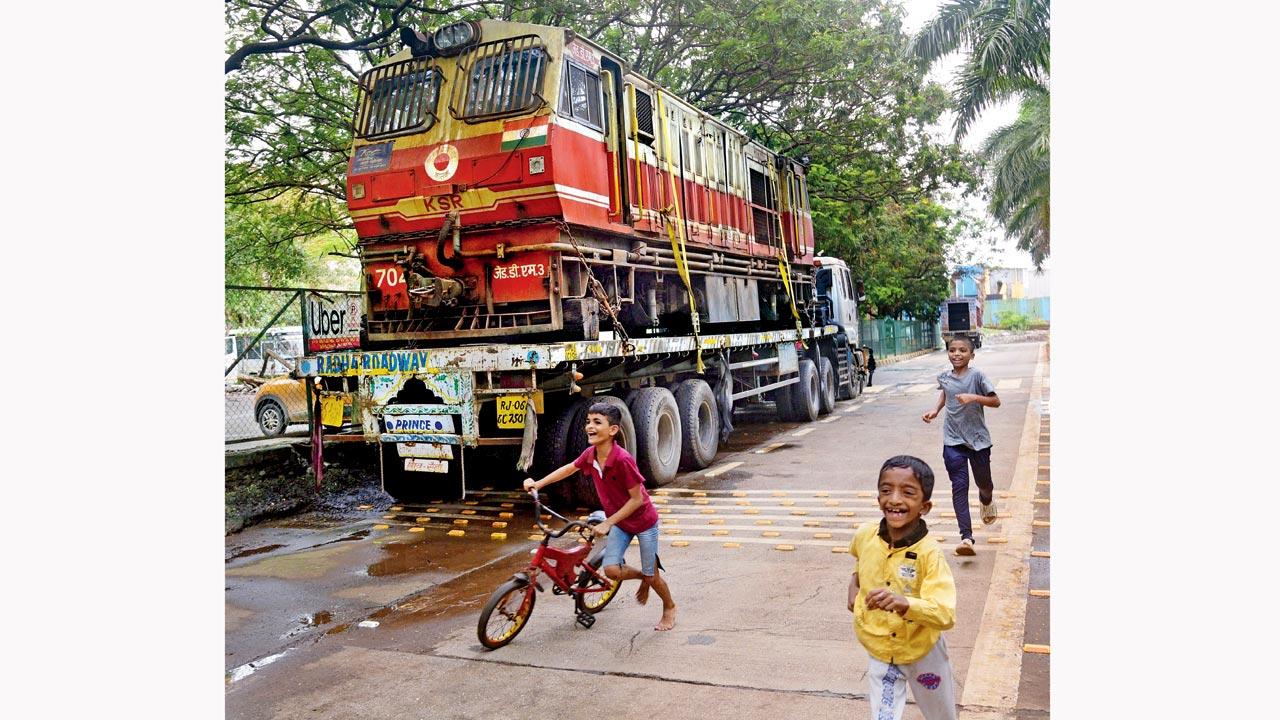 In this photo that captures almost all modes of transport, children play around a railway engine perched on a parked truck at Wadala. Pic/Pradeep Dhivar