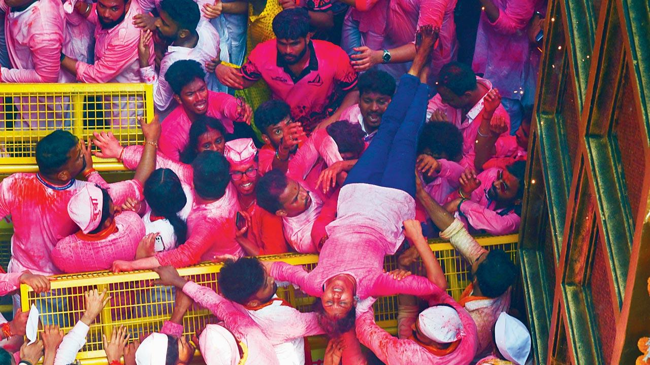 A woman who fainted while waiting for a glimpse of Lalbaughcha Raja is helped to safety by the other devotees, even as the city celebrated its first normal Ganeshotsav in three years. Pic/Shadab Khan