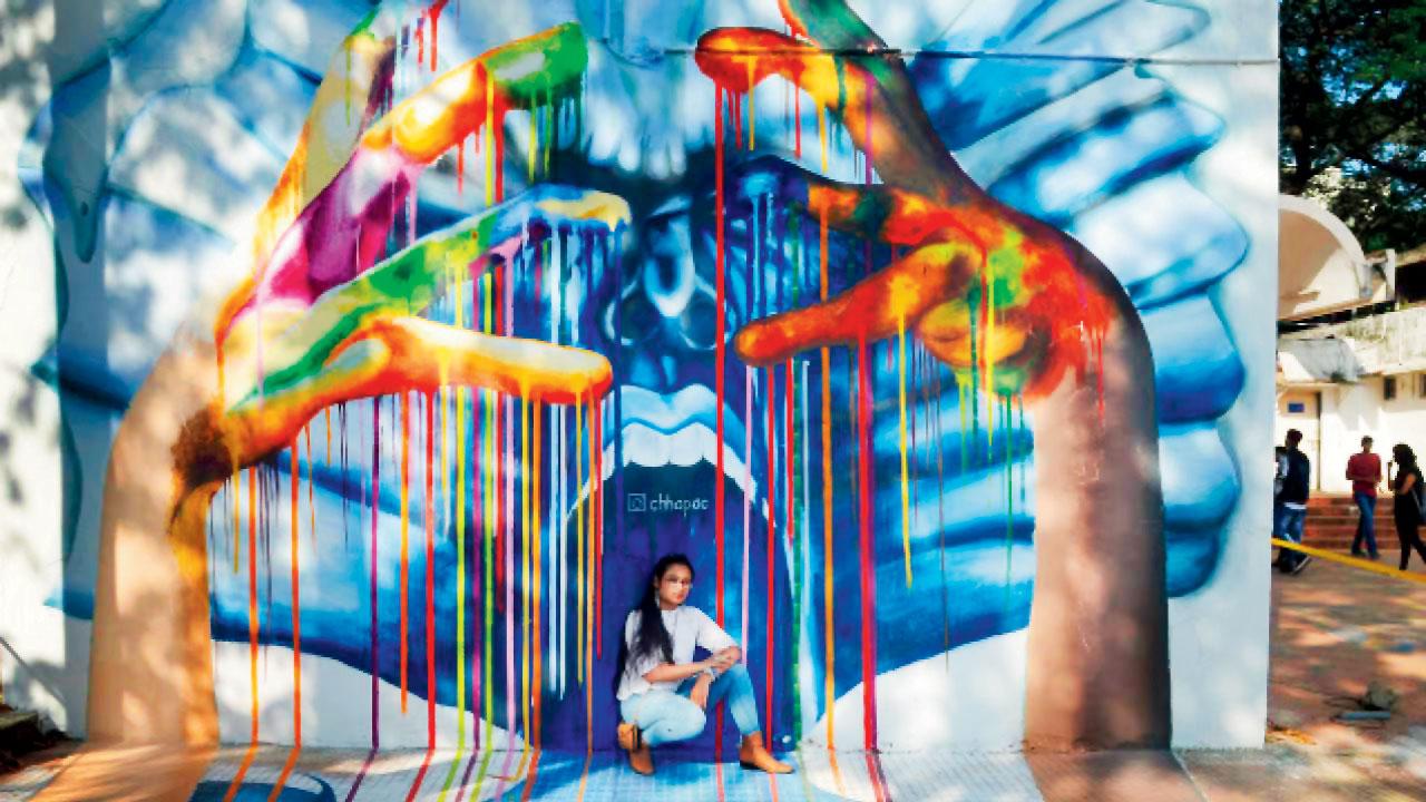 A girl poses by a graffiti mural at IIT Bombay during the previous edition