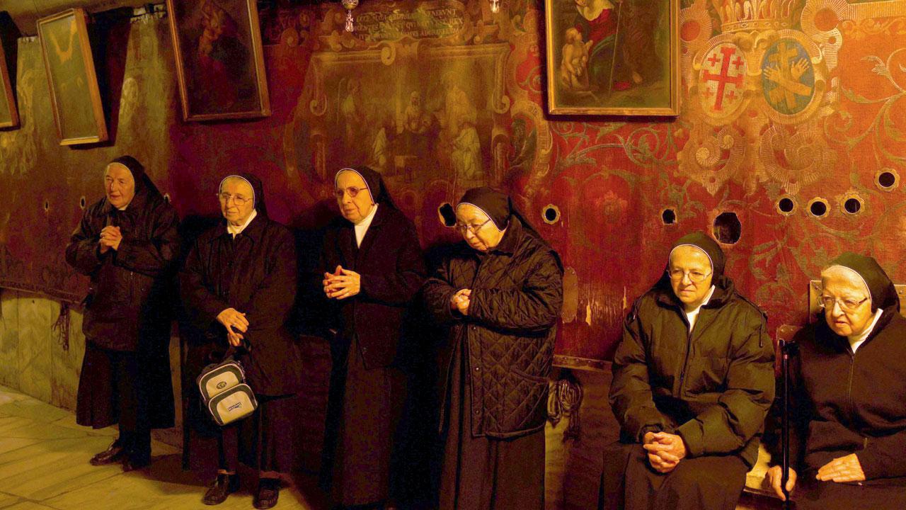 Nuns pray inside the Grotto, believed to be the birthplace of Jesus Christ on Monday. Pic/AFP