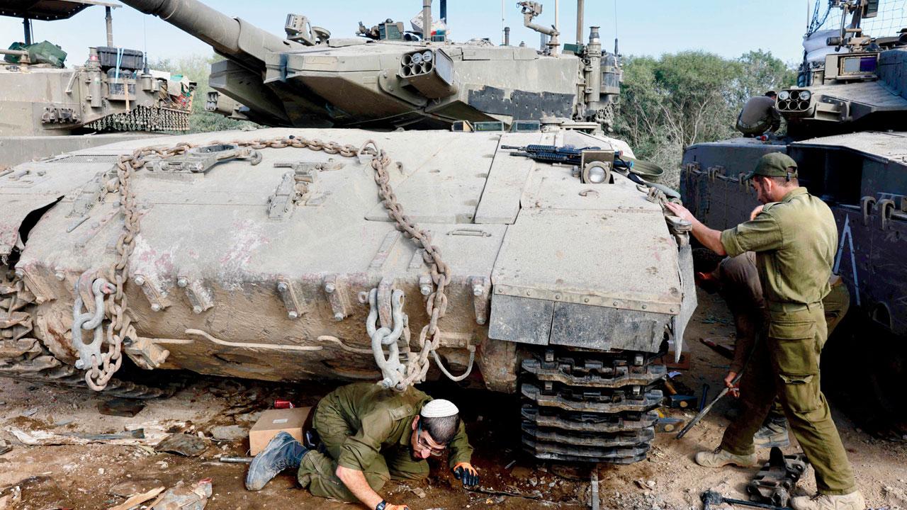 Israeli soldiers gather around tanks near the border with the Gaza Strip on Monday. Pic/AFP