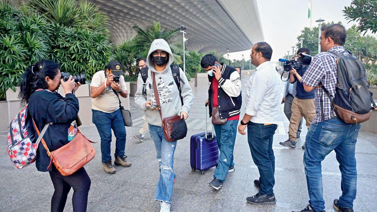 Media representatives take pictures of passengers arriving from France. Pic/PTI