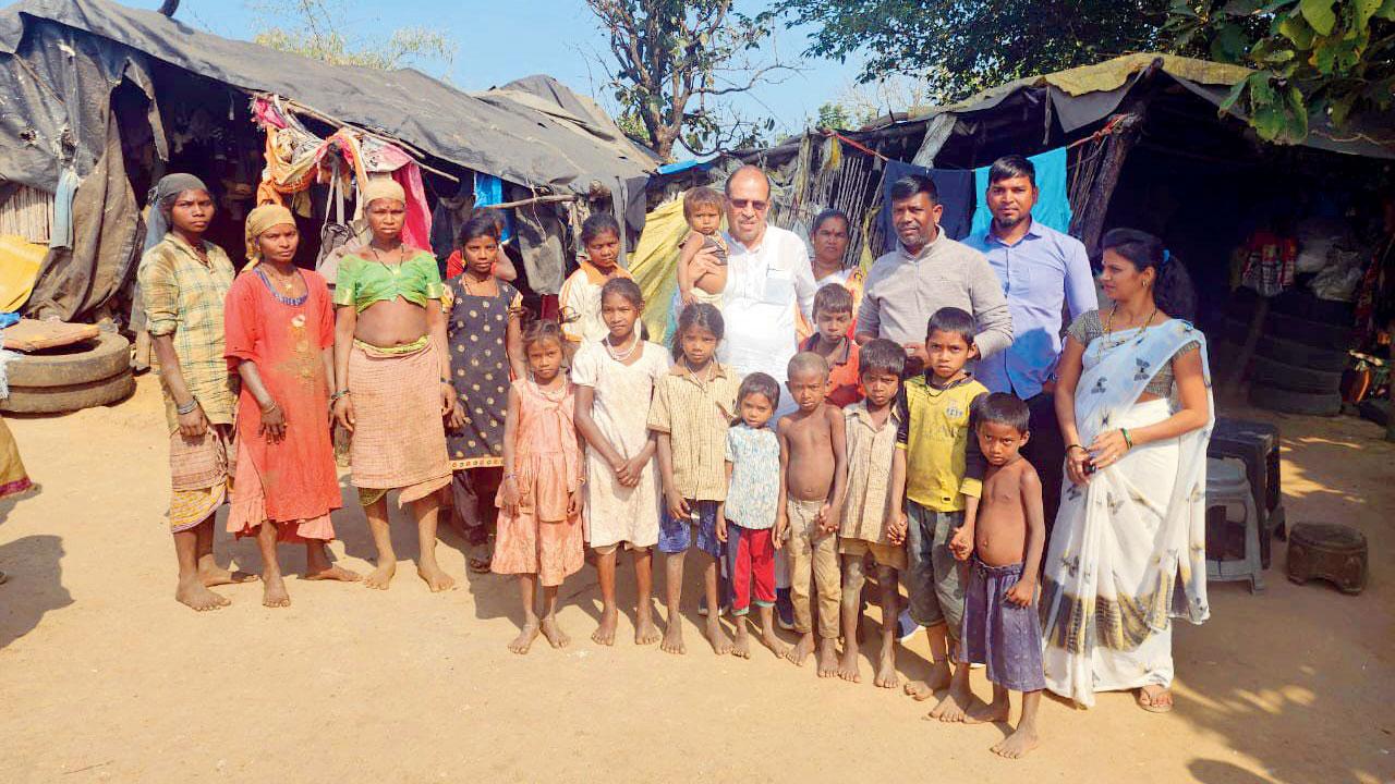 Tribal leader Vivek Pandit is holding a child in his lap immediately after rescuing them in Bhiwandi