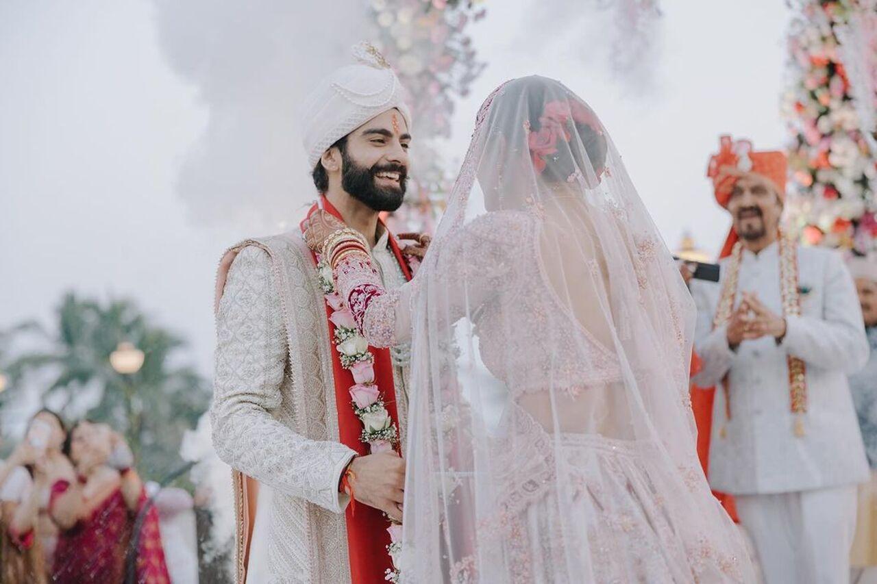 In this picture, Mukti placed a beautiful white and pink var mala around Kunal's neck