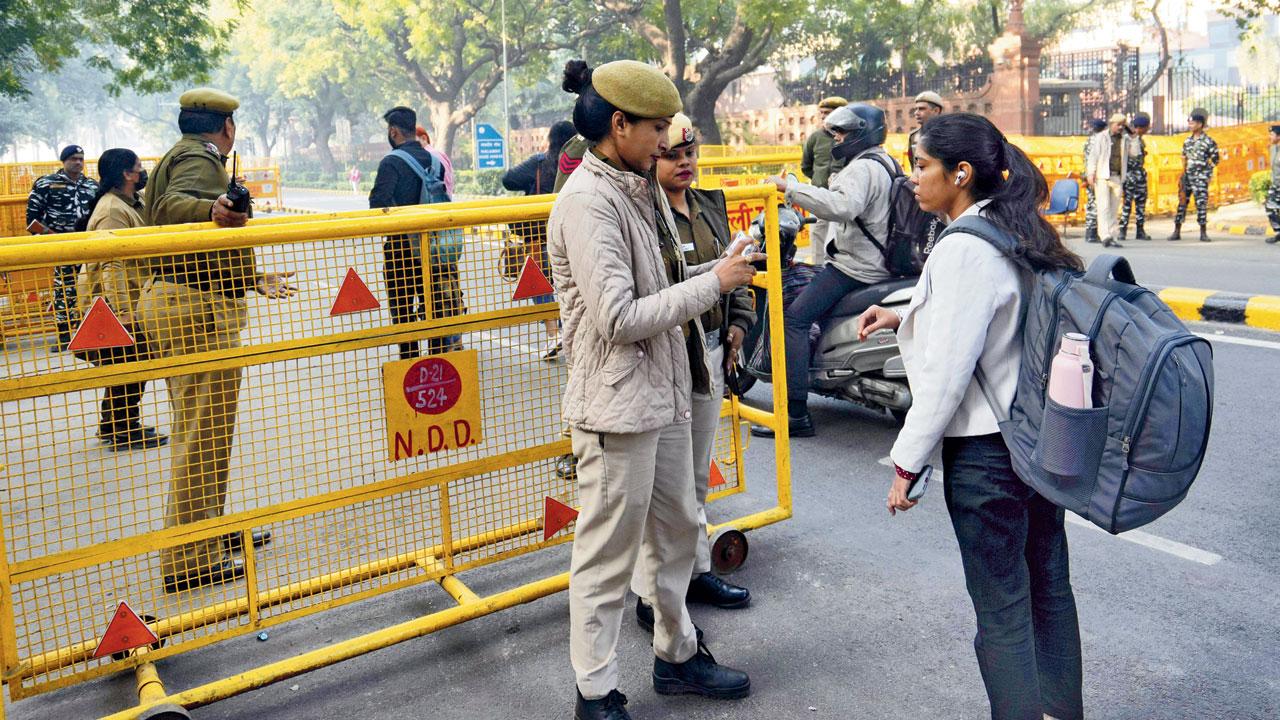 Police personnel check identification card of a commuter near the Parliament House. File Pic/PTI