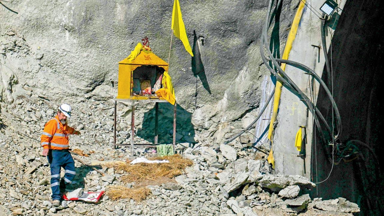 Dix prays to the local deity Baba Boukhnag at the mouth of the collapsed under-construction tunnel