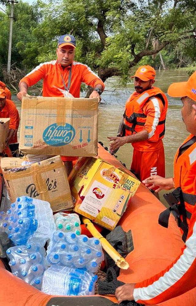 Visuals from Thoothukodi showed the NDRF personnel rescuing people from flooded areas and delivering food packages. 