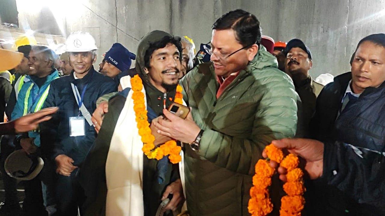 Uttarakhand Chief Minister Pushkar Singh Dhami with a rescued worker inside the tunnel on November 28. Qureshi says that when he first got to the workers, elated, they offered him a chocolate. Pic/Getty Images