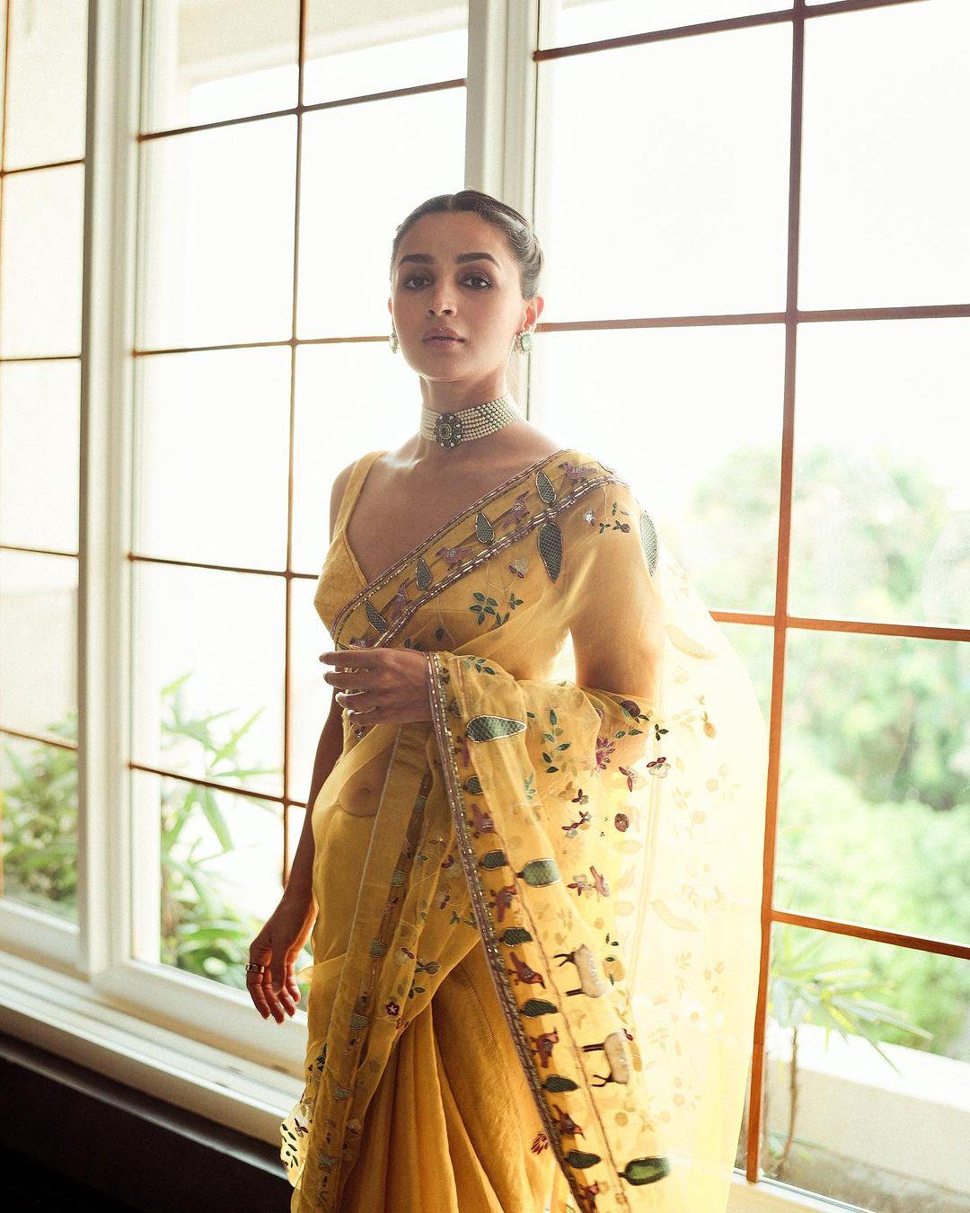 The saree was a masterpiece in itself, with intricate flower motifs carefully embroidered onto the fabric. The choice of colours used in the embroidery complemented the base colour of the saree, making it a sight to behold. The blouse that accompanied the saree was a bold yellow, with a plunging neckline 