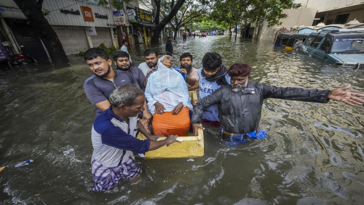 People help an elderly woman shift to a safer place from a flooded area after heavy rainfall owing to Cyclone Michaung, in Chennai, Tuesday, Dec. 5, 2023. PTI Photo