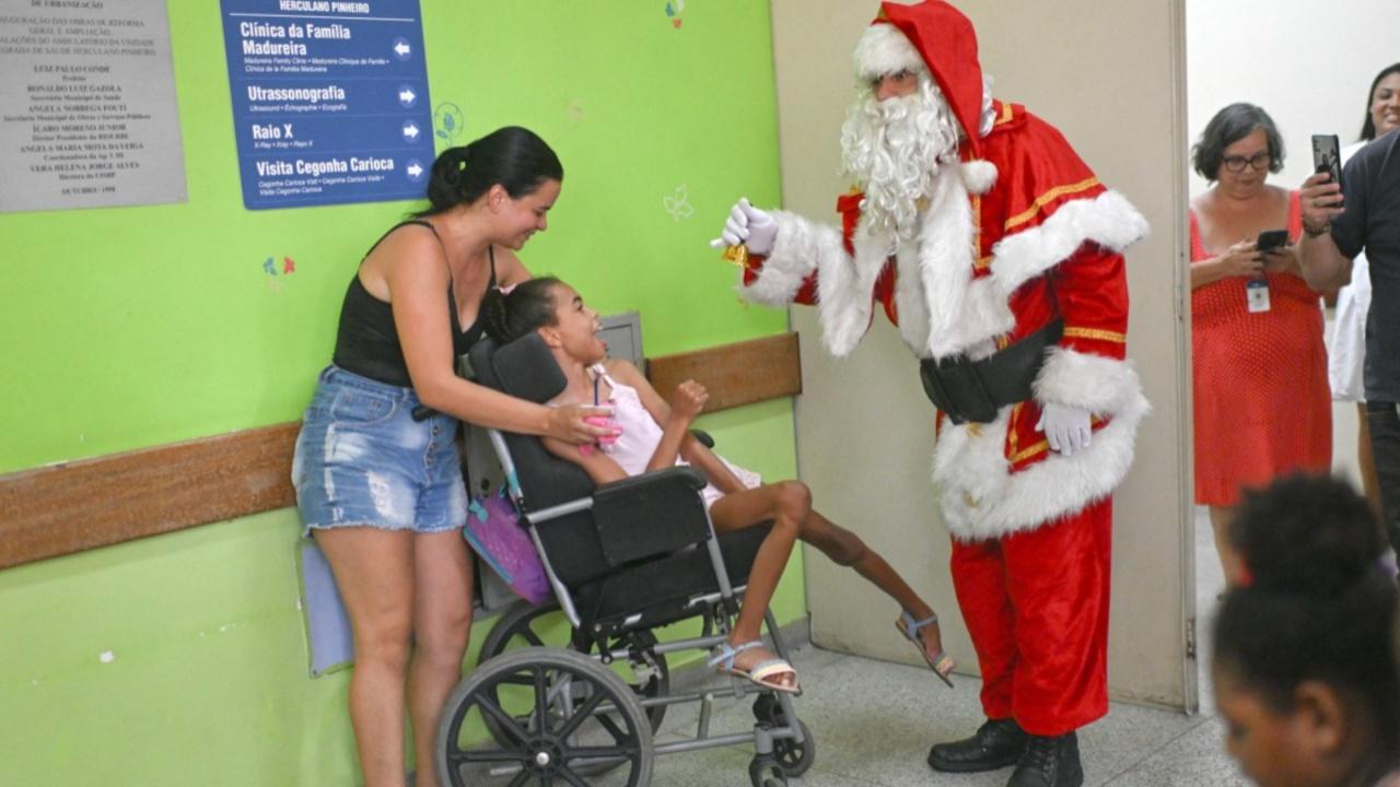Public worker Ari Queiroz, 60, dressed as Santa Claus, talks to a patient during a Christmas party at the Herculano Pinheiro Maternity Hospital in Rio de Janeiro, Brazil. Queiroz, who distributes vaccines and medicines for the Health Department of Rio de Janeiro, has been turning into Santa Claus every Christmas and visiting hospitals for the past two decades (Photo by MAURO PIMENTEL/AFP)