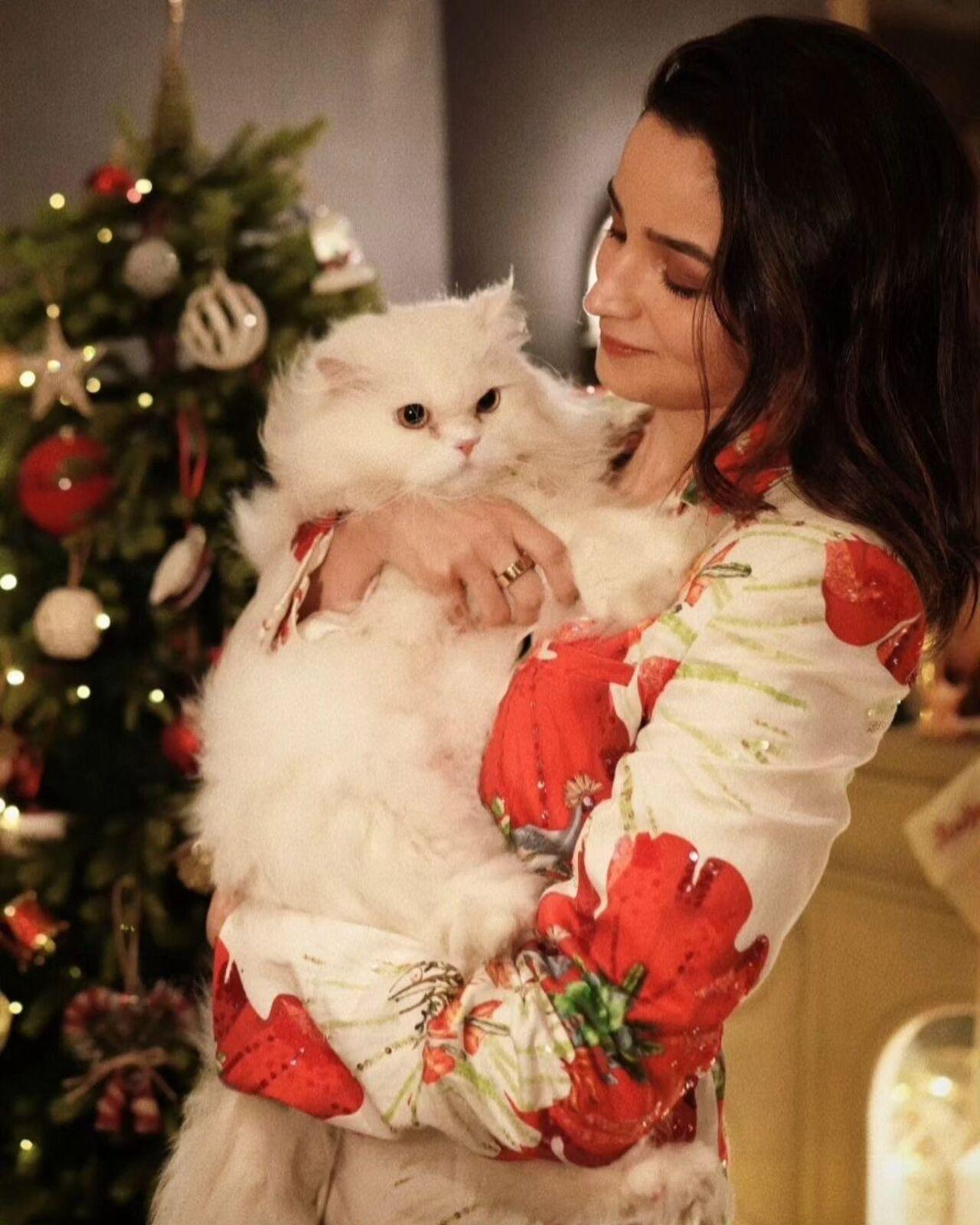 Alia Bhatt sent out season greetings with a photoshoot of herself dressed in a white and red powersuit. She is seen posing in the foreground of a Christmas tree