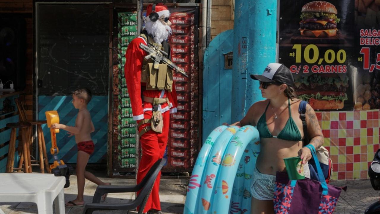 A mannequin depicting Santa Claus wearing a military vest and with a toy gun is seen in the west zone of Rio de Janeiro, Brazil, on December 25, 2023. (Photo by Tercio TEIXEIRA/AFP)