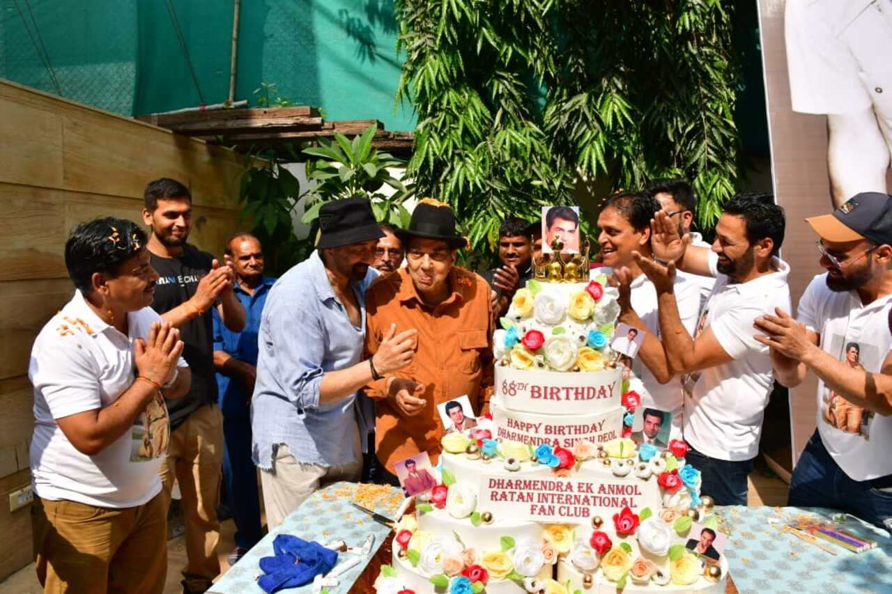 Several pictures and videos of the 'Sholay' actor cutting a giant 7-tier cake in front of his fans went viral on social media. The massive cake featured the actor's photos and colourful, edible roses