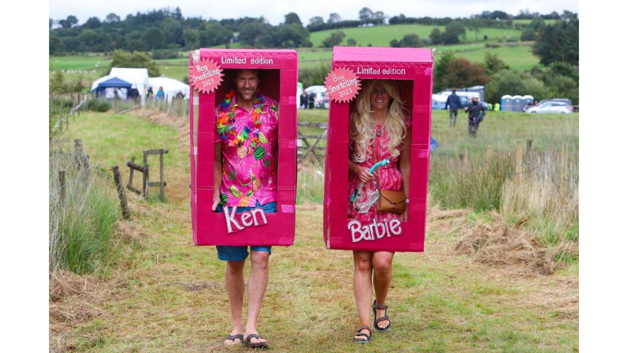 Competitors dressed as Barbie and Ken arrive to the World Bog Snorkelling Championships held at the Waen Rhydd peat bog, Llanwrtyd Wells, Mid Wales, on August 27, 2023. The race is held along a 55-metre bog trench, in which the contestants must complete two lengths. Conventional swimming strokes are not allowed, though snorkels and flippers are mandatory. (Photo by Geoff Caddick/AFP)
