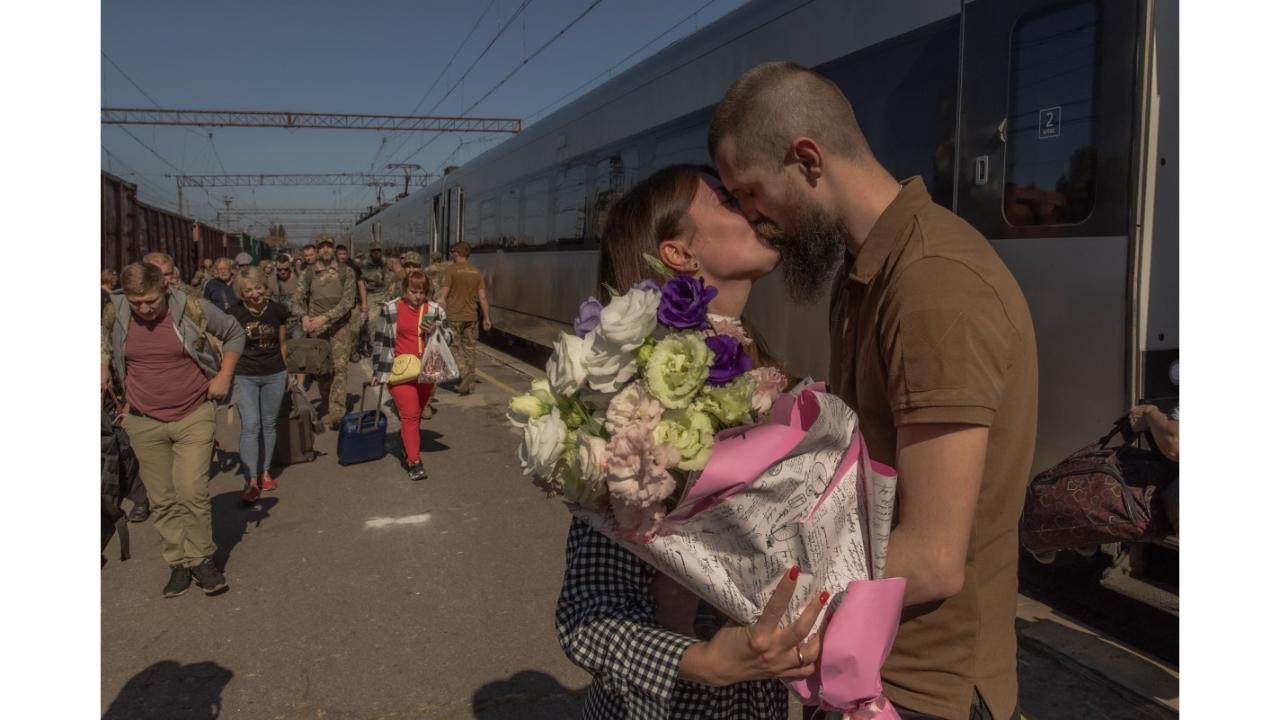 Oleksiy (L), a Ukrainian serviceman, kisses his wife Maryna, who arrived on a train from Kyiv to visit him, at the railway station in Kramatorsk, Donetsk region, on September 25, 2023, amid the Russian invasion of Ukraine. (Photo by Roman Pilipey/AFP)