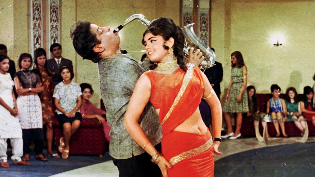 Actor Mumtaz wears an orange stitched-draped saree in Brahmachari (1968) 