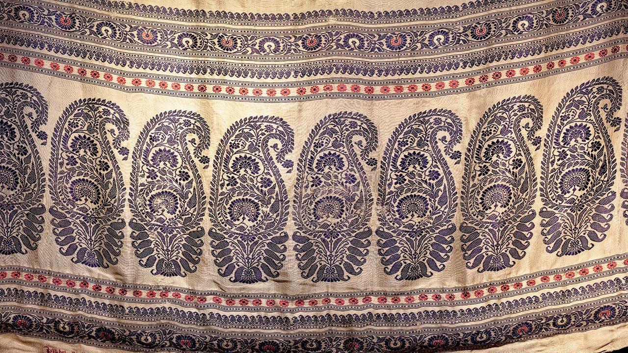 This Baluchari butidar silk saree with the kalka (paisley) motif has an inscription of the weaver, Dubraj Das from Mirpur (present day, Bangladesh). In the midst of protests against mill-made “Made in Manchester” and “Made in Austria” textiles flooding the Indian market, this piece upholds the importance of skill, attested by the weaver by signing his name as if in protest. The signature asks us to think whether the weaver considered himself an artist