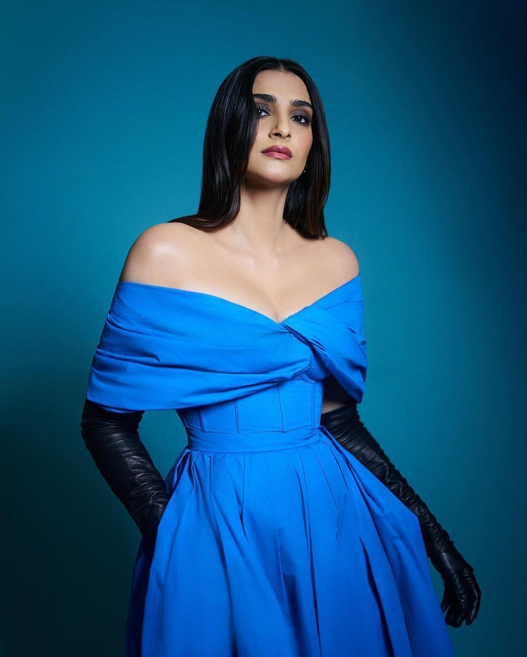 Sonam Kapoor served looks in this off-shoulder blue dress from Alexander McQueen. She paired the dress with black gloves that raised the ensemble to another level