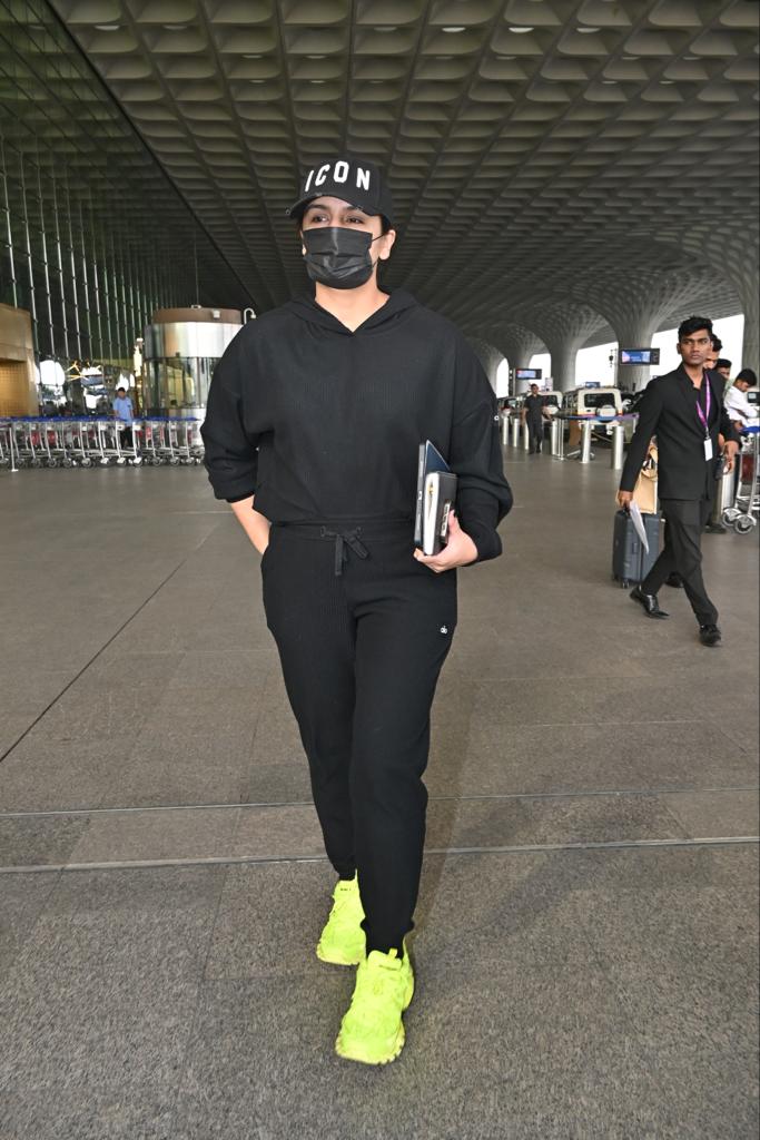 Huma Qureshi opted for an all-black outfit and paired it with contrasting neon sneakers to ace her airport look