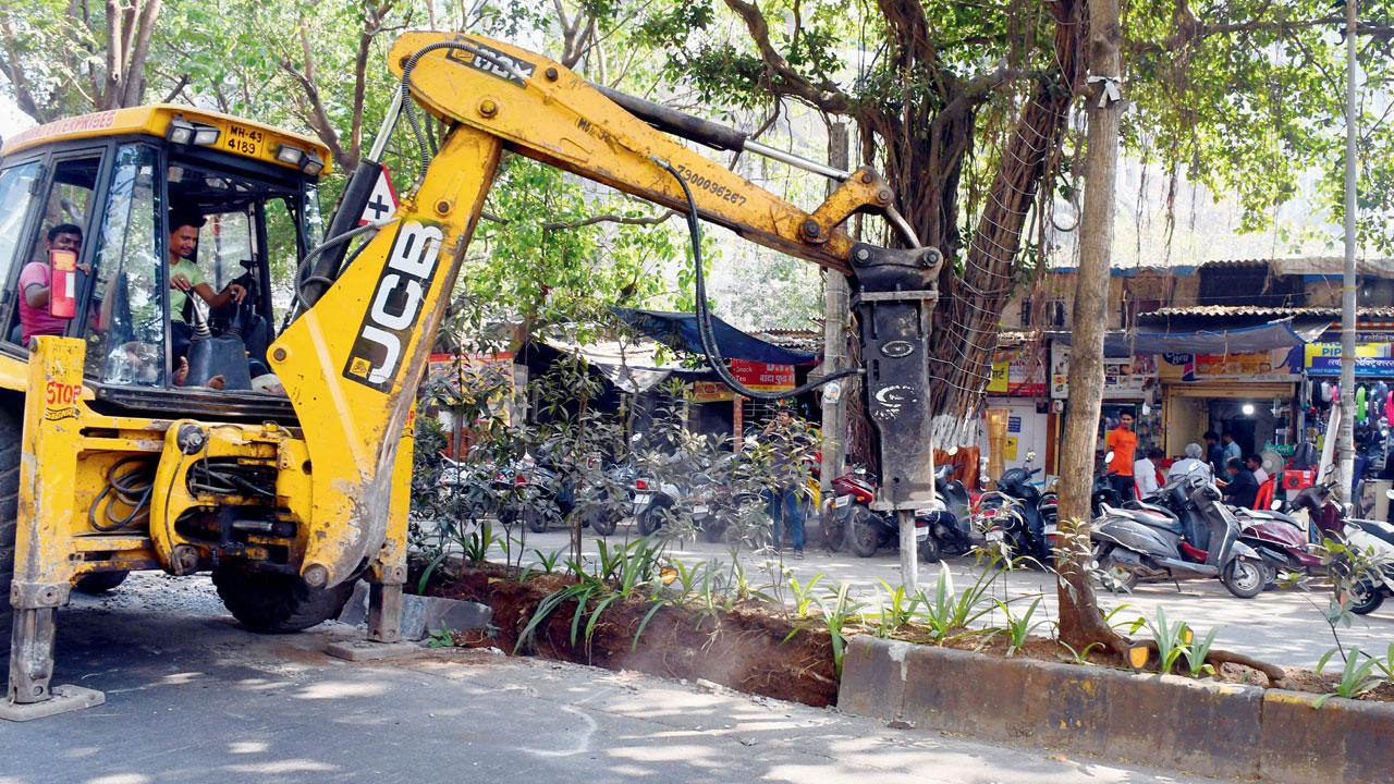 BMC workers demolish a perfectly intact divider on Jagat Vidya Marg in Bandra East. Pic/Ashish Raje