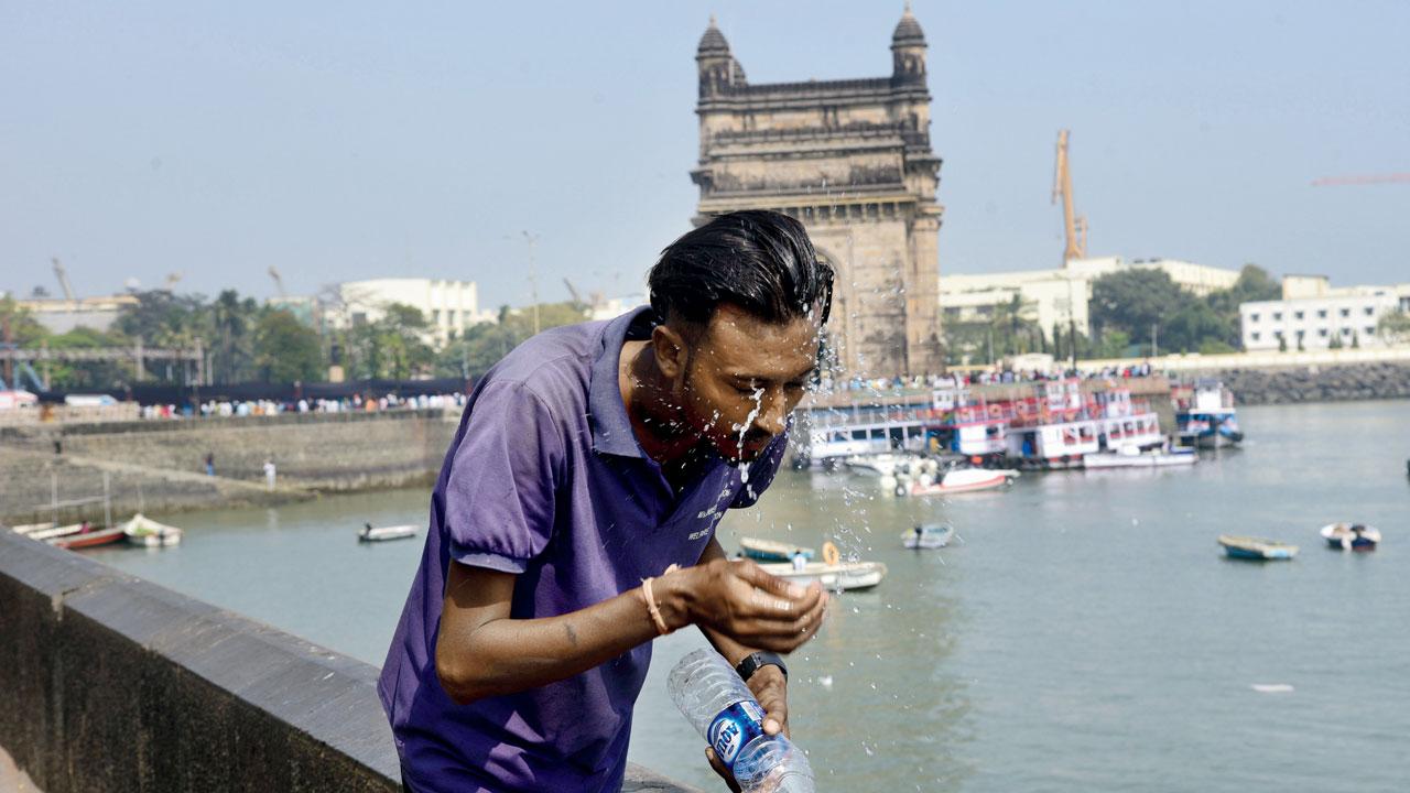A boy tries to get relief from the scorching heat at the Gateway of India, Colaba. File Pic/Pradeep Dhivar