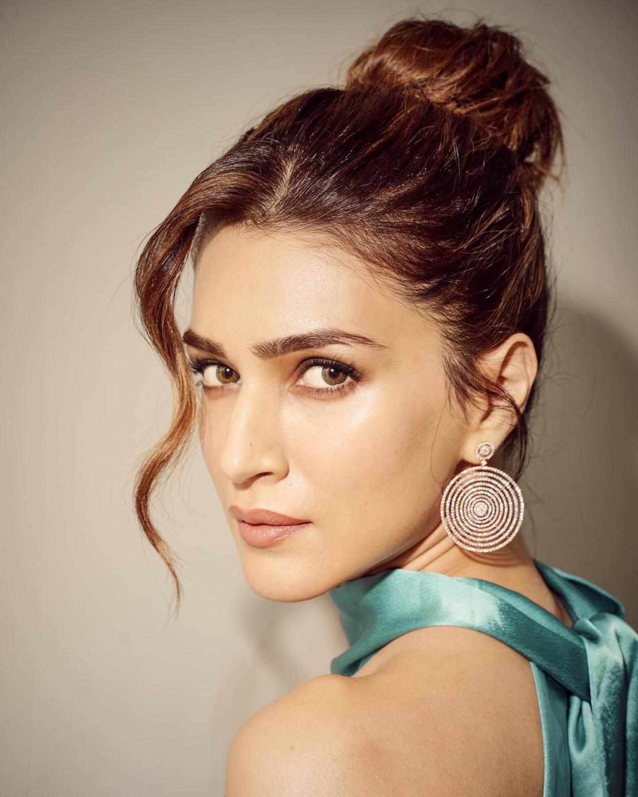 Kriti completed her look with statement silver earrings, a silver bracelet, finger rings and silver sequined stilettos. She tied up her hair in a messy bun and let a few strands of hair frame her face