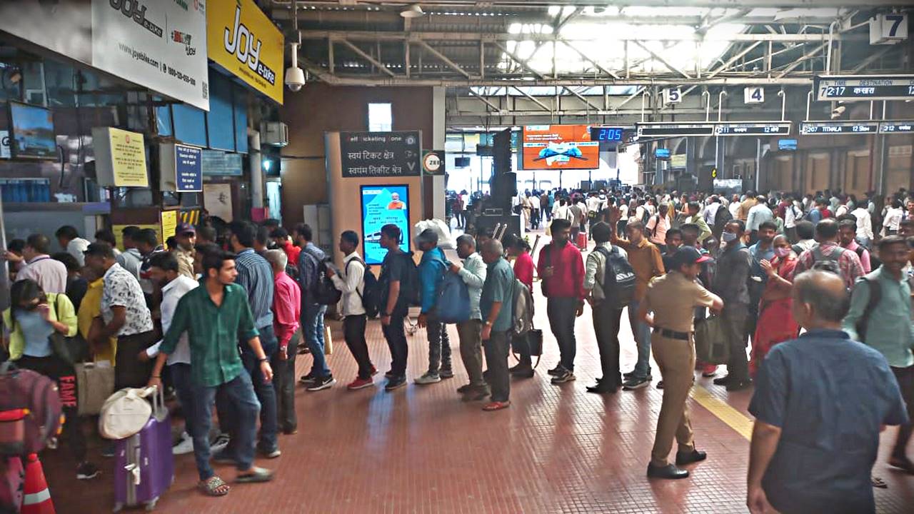 Passengers standing in queue at the railway station to book train tickets amid heavy rush.