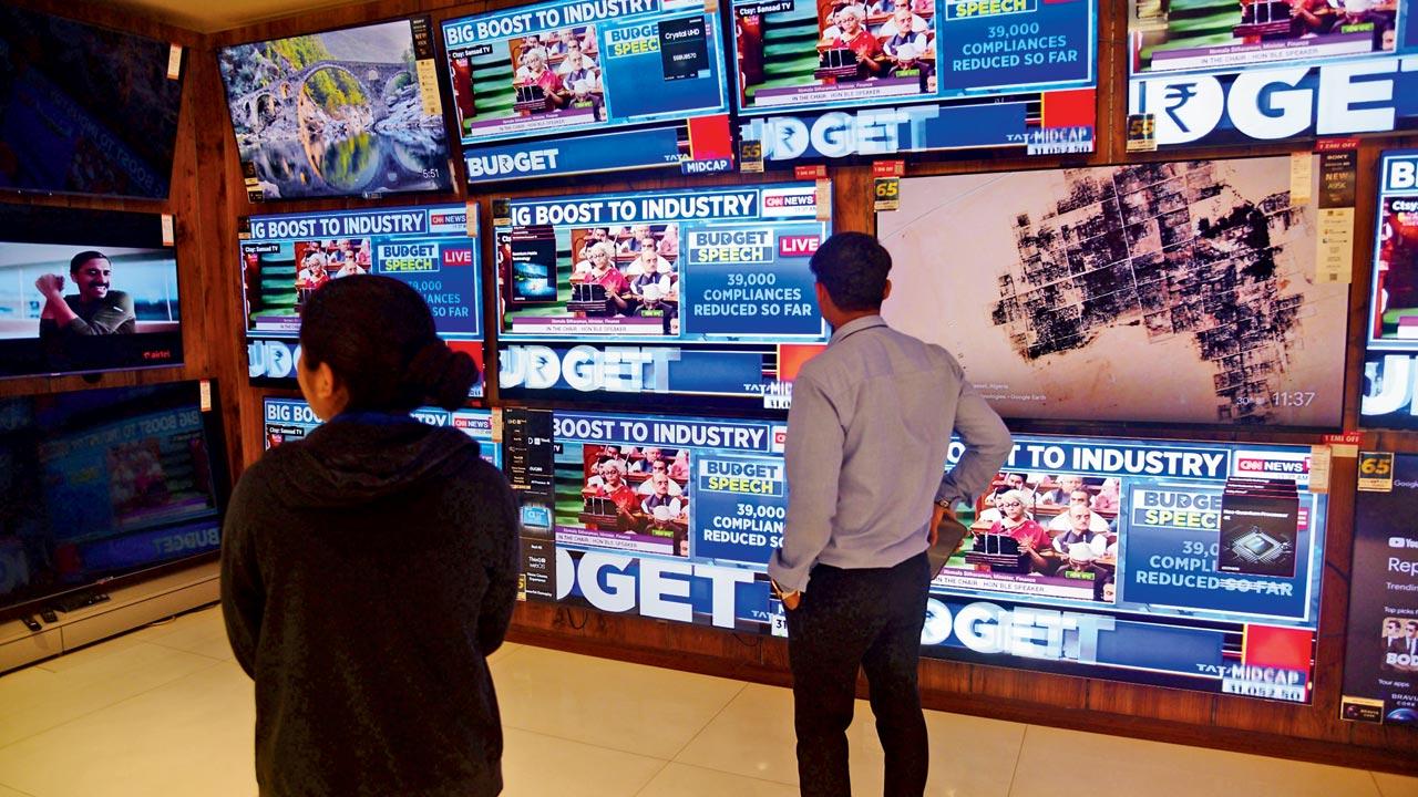 People watch Union Budget 2023 announcements at a shop in Dadar on Wednesday. Pic/Pradeep Dhivar