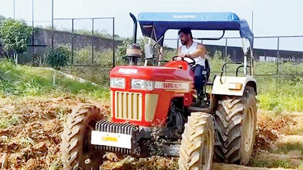 Dhoni learns to drive a tractor!