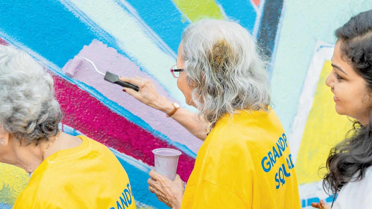 A senior citizen contributes to the artwork at Sassoon Dock