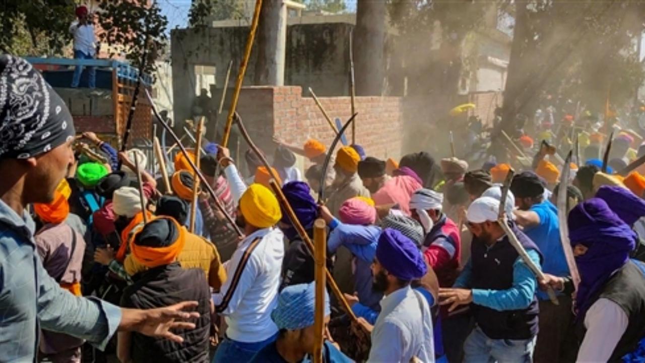 Followers of 'Waris Punjab De' founder Amritpal Singh clash with the police while breaking through barricades at the police in protest against filing of FIR against him and his associates, at Ajnala near Amritsar