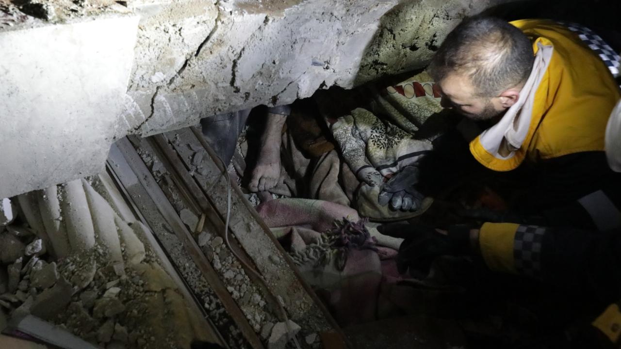 Syrian rescuers (White Helmets) try to retrieve an injured man from the rubble of a collapsed building follwoing an earthquake, in the border town of Azaz in the rebel-held north of the Aleppo province, early on February 6, 2023. At least 42 have been reportedly killed in north Syria after a 7.8-magnitude earthquake that originated in Turkey and was felt across neighbouring countries
