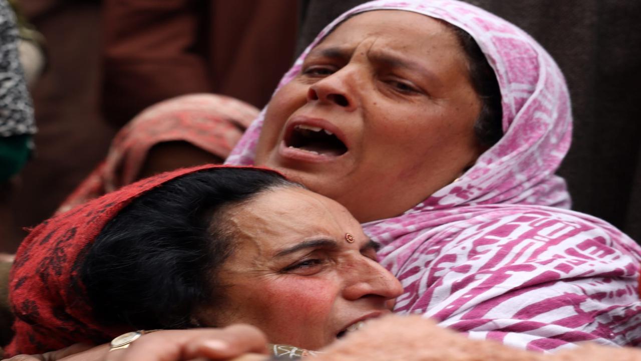 Family members and the Muslim neighbours mourn near the body of slain Kashmiri Pandit ATM guard Sanjay Pandith who was killed by militants in Achan area of Pulwama in south Kashmir on Sunday. Photo/Pallav Paliwal