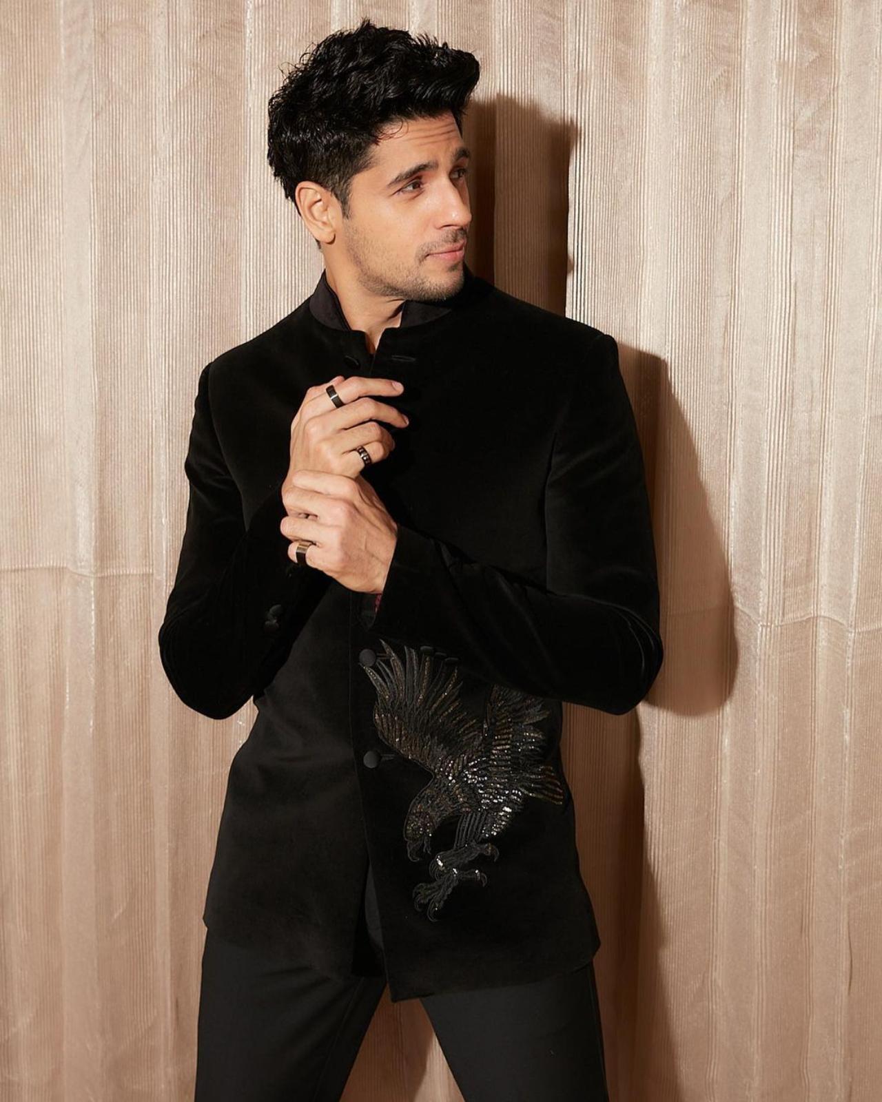 Hi Handsome!
It's a proven fact that Sidharth loves to play with black shades when it comes to fashion and especially, ethics. The Punjabi munda of B-town made headlines when he posted a string of pictures donning a beguiling black bandhgala suit. The velvet jacket which had a finely embroidered and embellished eagle patch was the key highlight of Sid's ethnic suit. Giving royal vibes, the actor slayed as he paired up his designer bandhgala jacket with straight-fit black formal pants. The 'Mission Majnu' star glamourised his ethnic look by wearing shimmery silver loafers. The heartthrob rounded off the luxe ethnic look by sporting black rings in both hands. After coming across this ethnic avatar of Sidharth, we are pretty sure that you have fallen head over heels for our handsome groom-to-be!