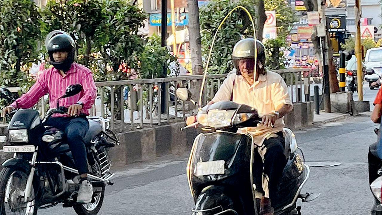 A man drives a two-wheeler with a protector in Surat