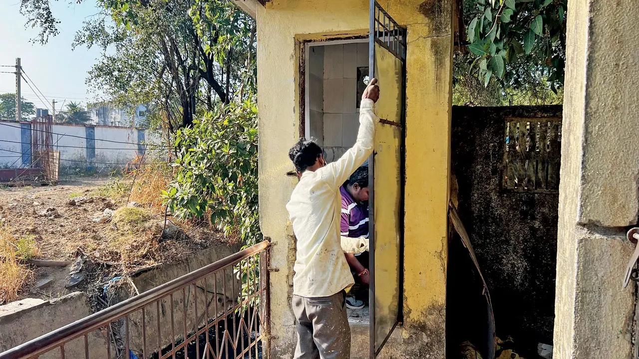 Workers attach the iron doors to the public toilets at Sant Jalaram Bapu Nagar chawl in Vasai East on Sunday Pics/Hanif Patel