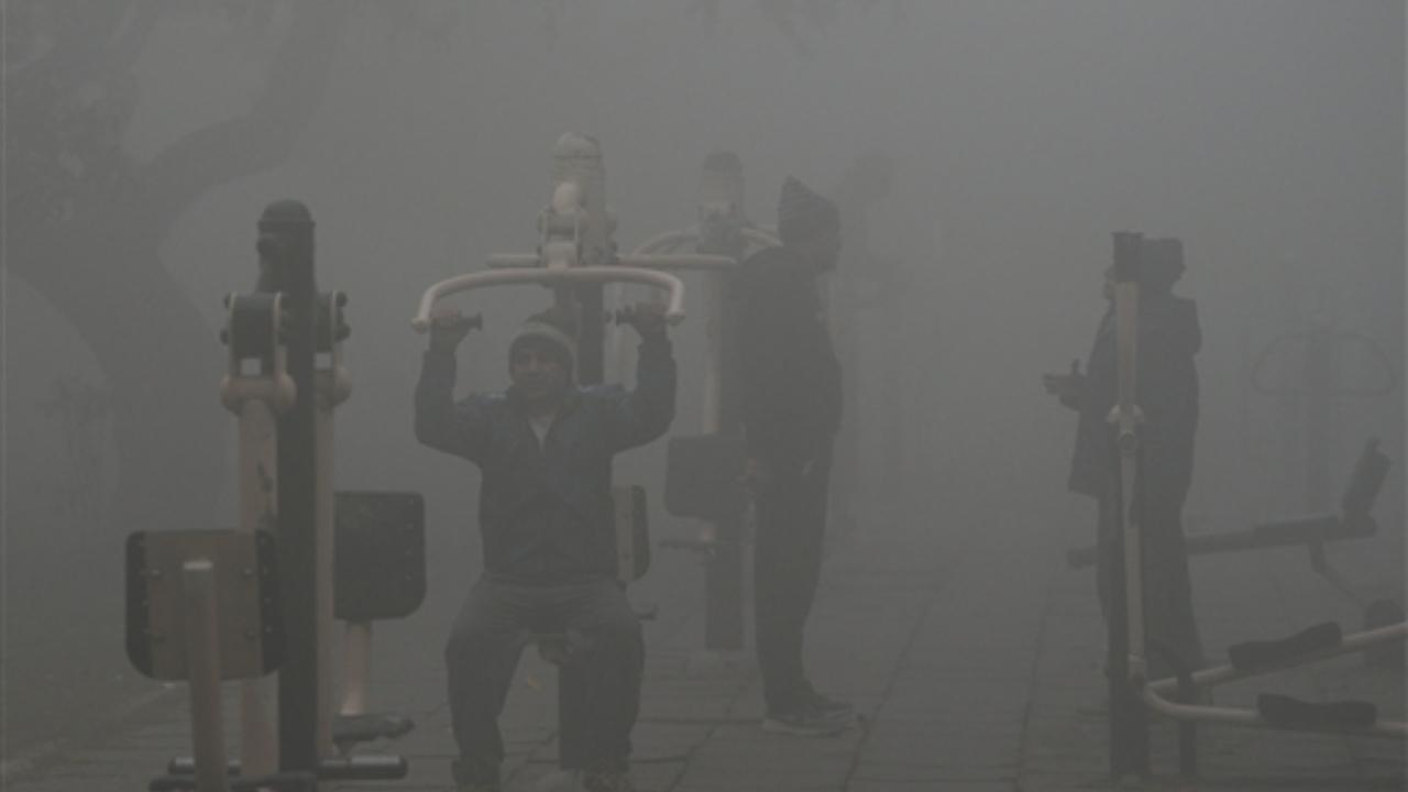 People exercise at an open gym in a park amid low visibility. The Safdarjung observatory logged a minimum temperature of 3.8 degrees Celsius as against 1.9 degrees on Sunday