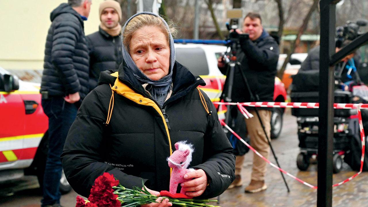 A woman brings flowers at the site where a helicopter crashed near a kindergarten in Brovary, outside the capital Kyiv killing 16 people Wednesday. Pic/AFP