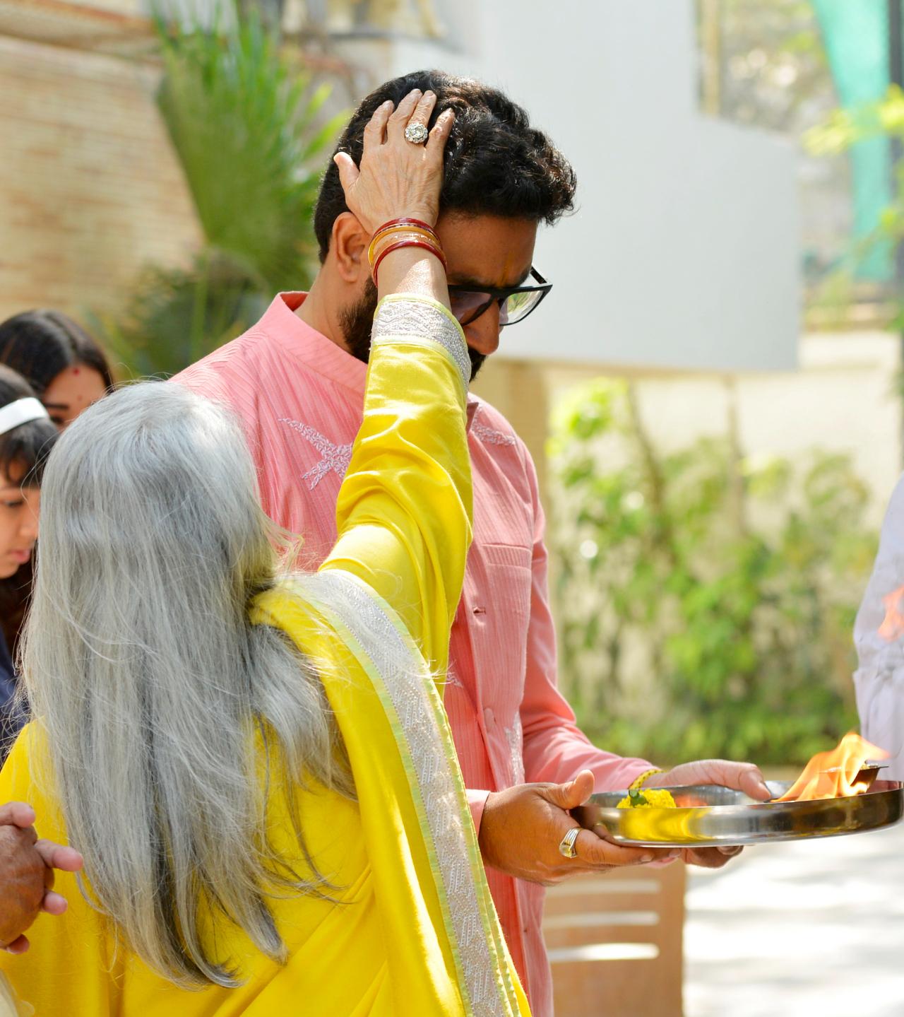 In one of the pictures, Jaya Bachchan can be seen blessing Abhishek Bachchan while he holds a puja thali. Jaya Bachchan was seen in a yellow suit for the puja