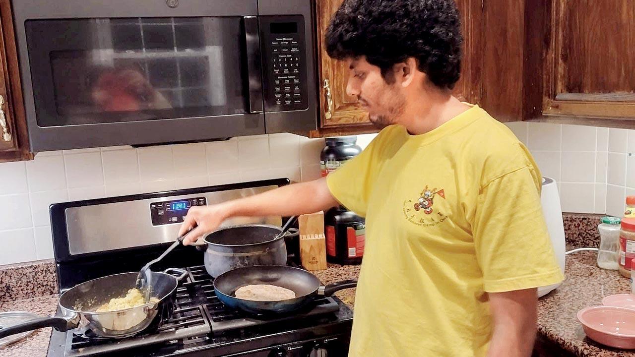 Jaykumar Vaidya prepares dinner at his plush apartment in Maryland