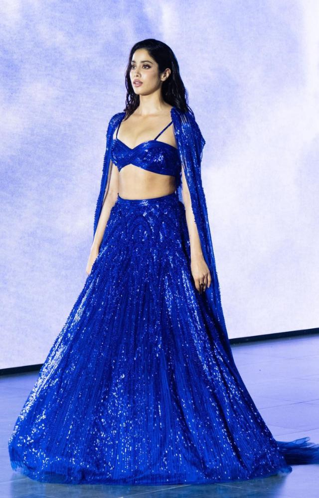 Janhvi Kapoor walked the ramp in a stunning midnight blue lehenga. She paired it with a bralette-style blue blous, free-flowing skirt and cape