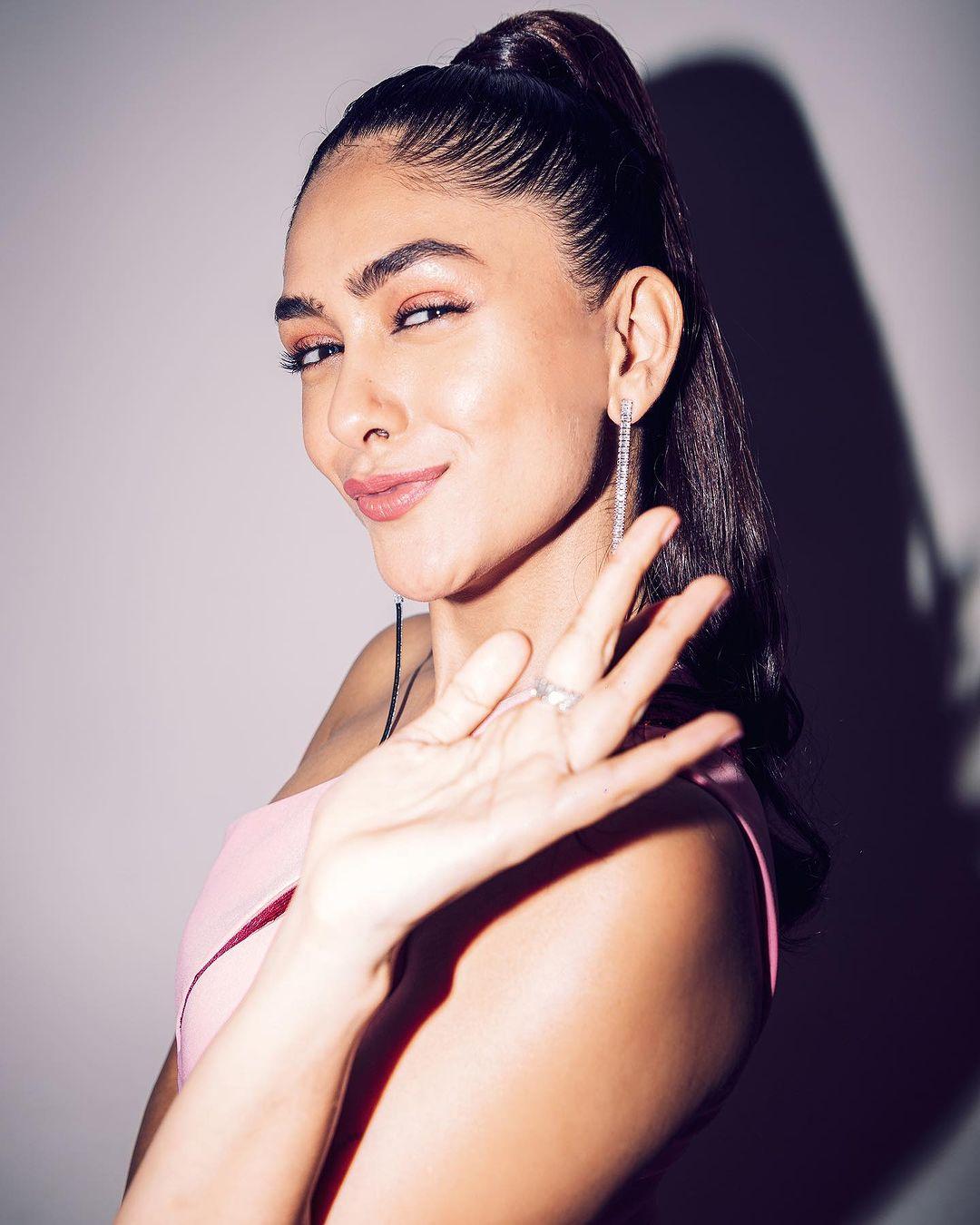 Mrunal Thakur graces the scene in an enchanting pink gown that exudes elegance and sophistication.