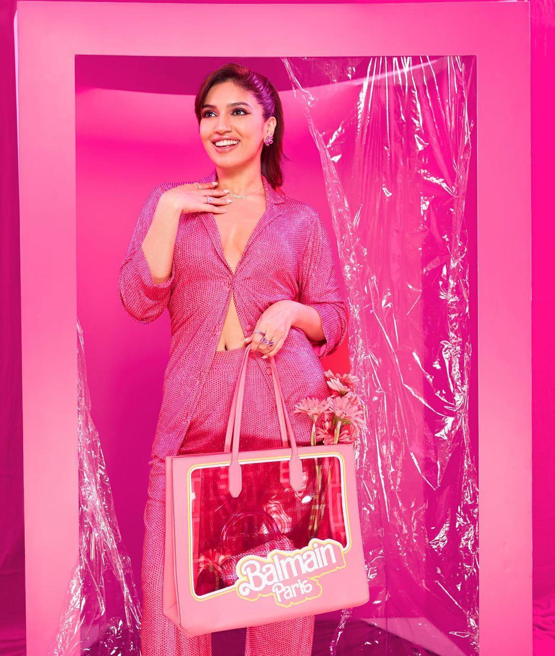The sparkles of the outfit catch the light, captivating all eyes as she enters the room. Her pose inside the Barbie box adds a playful touch, reflecting her vibrant personality and love for fashion.