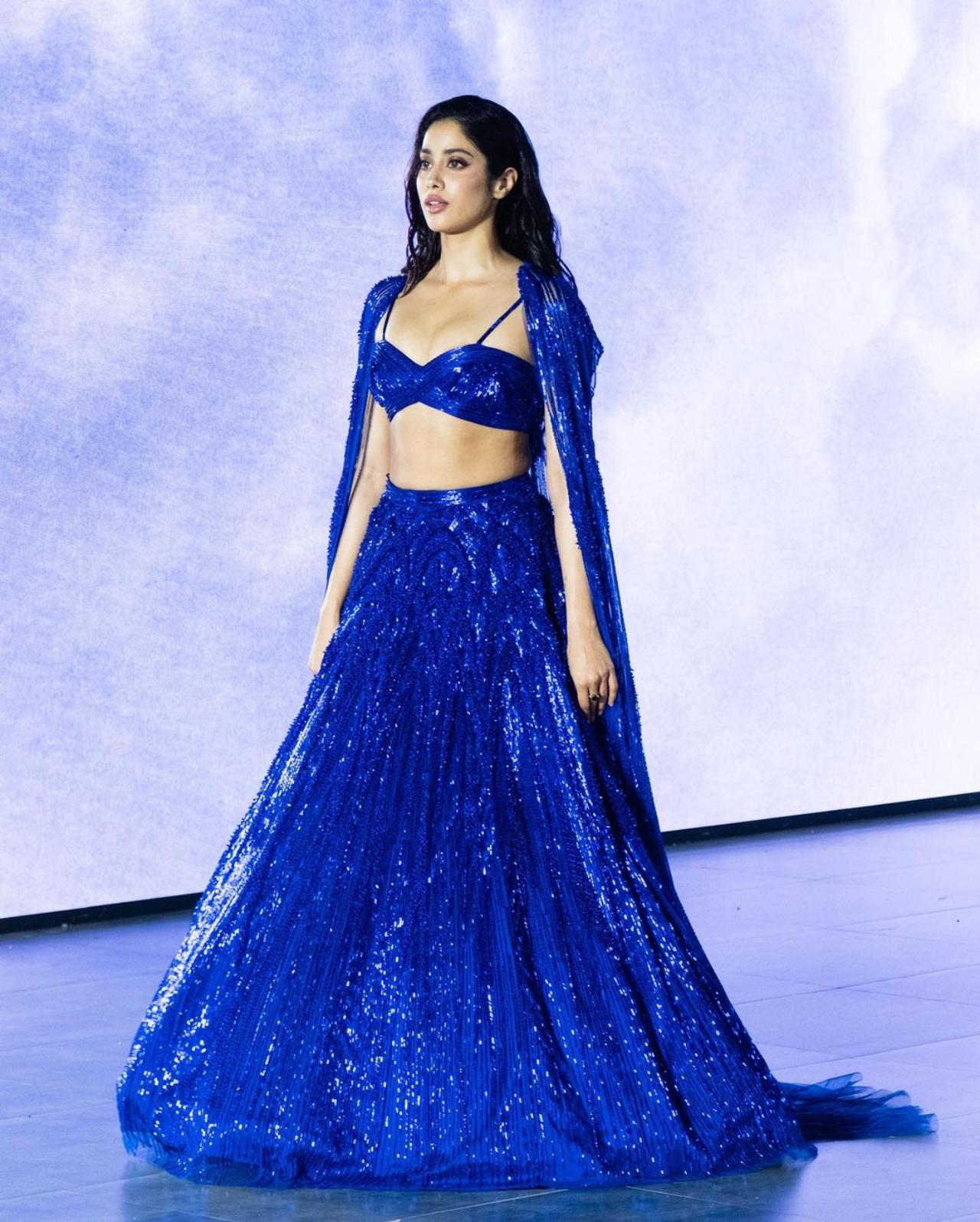 Jahnvi Kapoor stole the stage for Gupta's 'Hiranyagarbha' collection. She walked the ramp in a stunning midnight blue lehenga, whose electrifying colour, intricate embroidery and star-like glitter swept audiences away. Her outfit featured a bralette-style blue blouse with thin stripes and a plunging neckline. She paired it with a free-flowing long blue skirt and a cape, whose trail seemed to make her levitate. Truly magical!