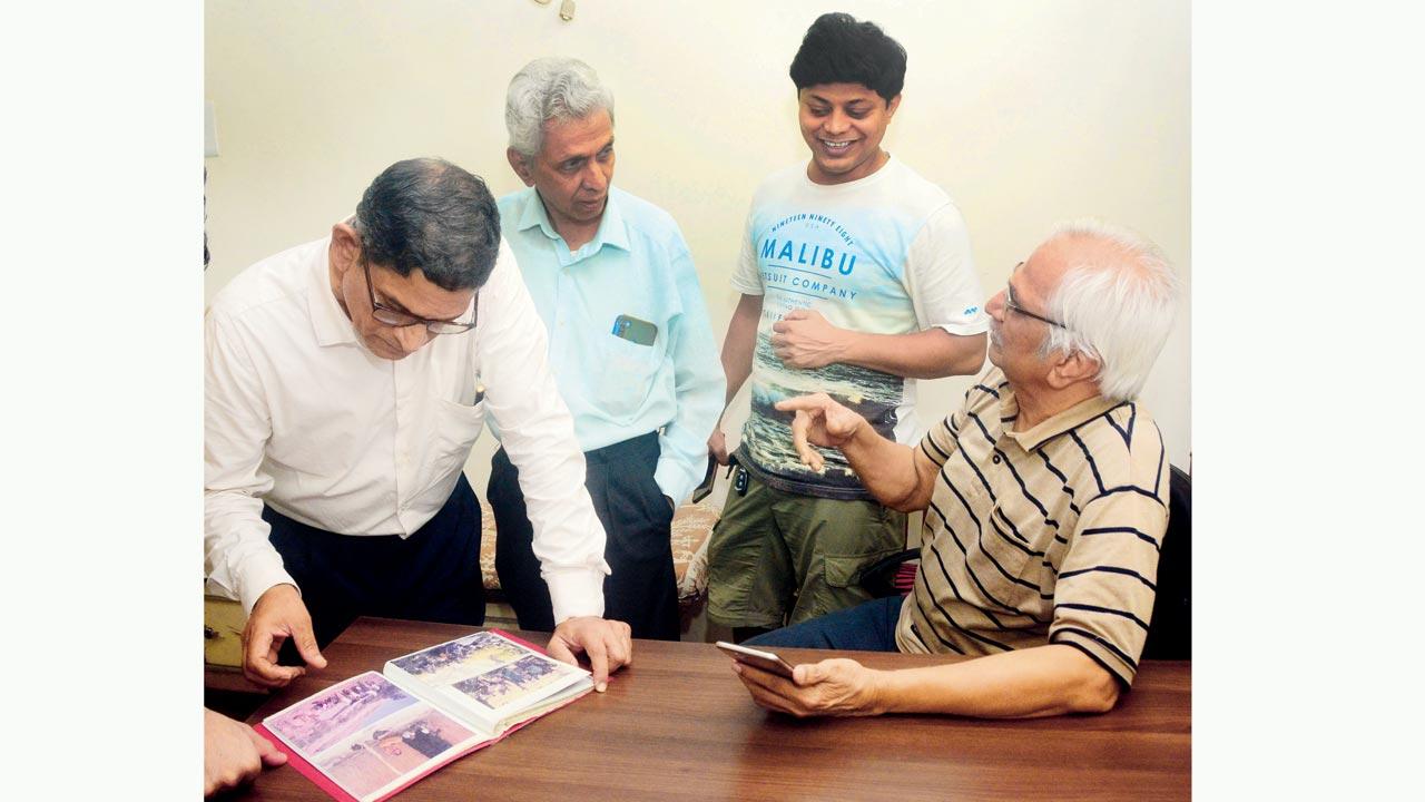 (From left) Shrikrishna Gokhale, Satish Waivude, Deveshu Thanekar and Ravi Dongaonkar, members of Thane-based NGO Janiv, flip through an album that holds memories of their work in ill-fated Irsalwadi, which they helped build from a tribal settlement to a bustling village. Pic/Satej Shinde