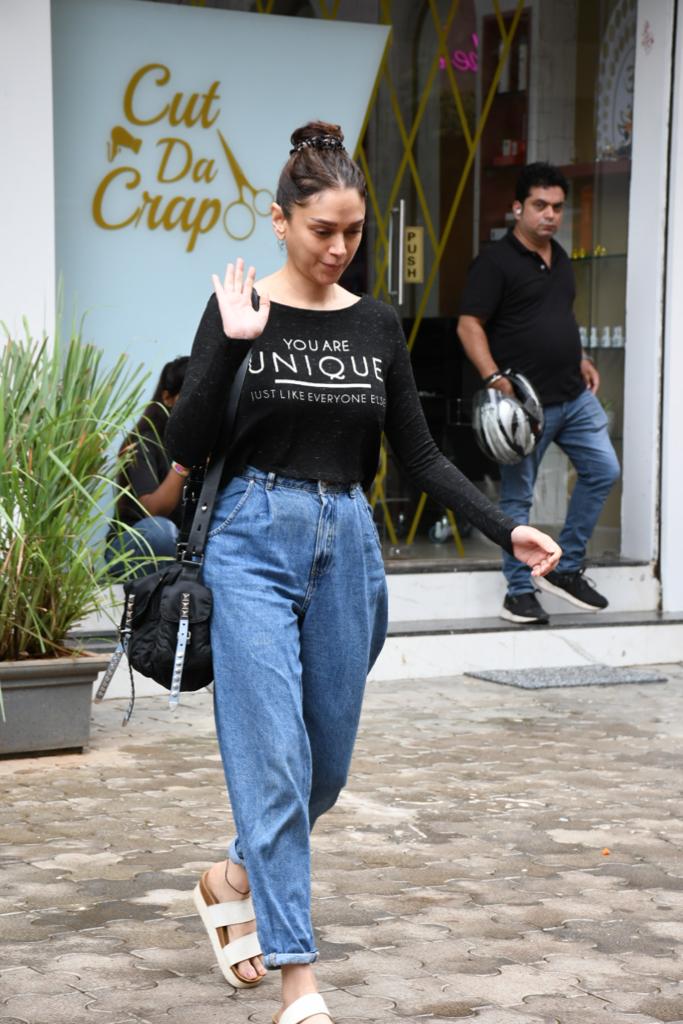 She paired the full-sleeved tee with simple blue jeans rolled up at the bottom, carrying a black bag. Aditi's casual yet witty style added a playful element to her overall look.