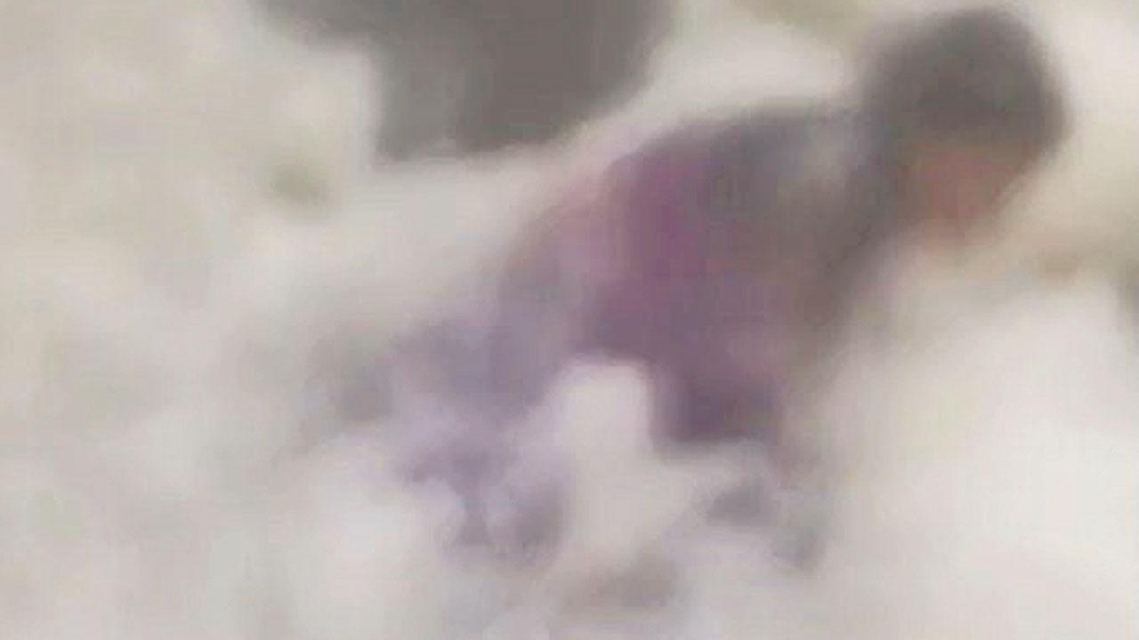 The moment when a wave drags the woman into the sea