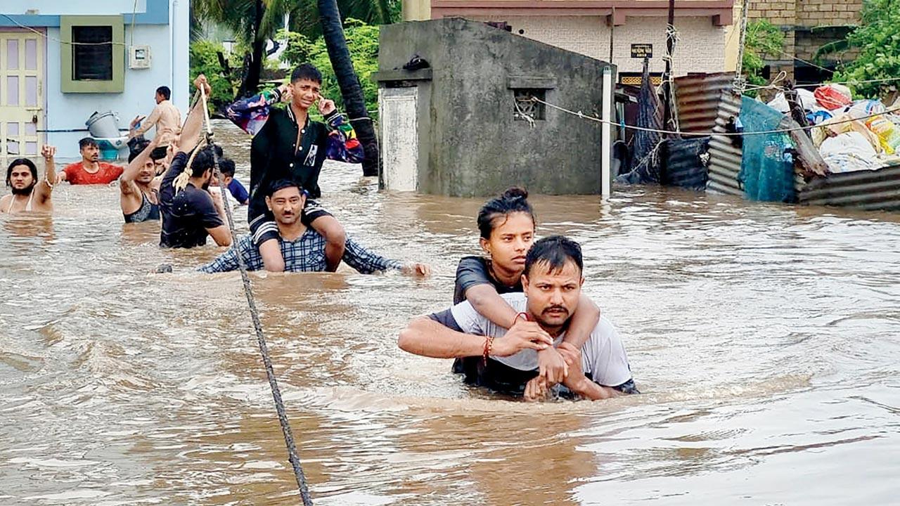 Residents being rescued from waterlogged Veraval. Pic/PTI