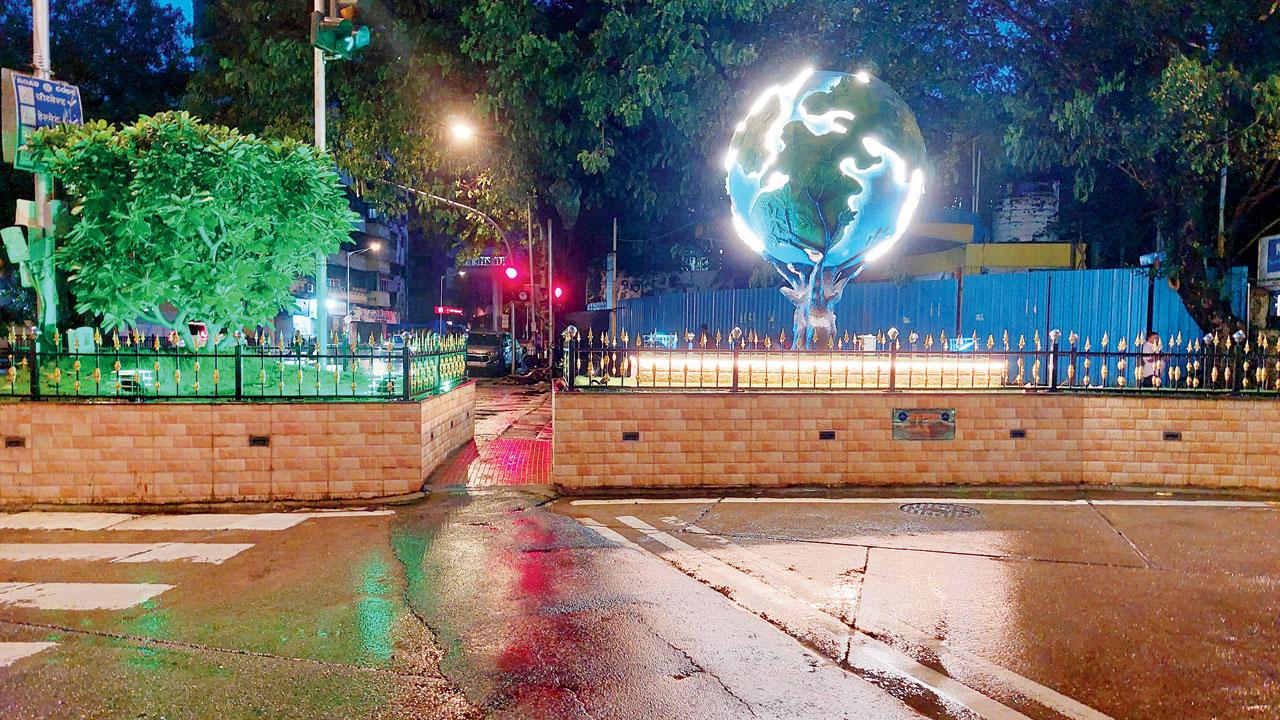 The globe on the traffic island in the day gets illuminated once the light fades
